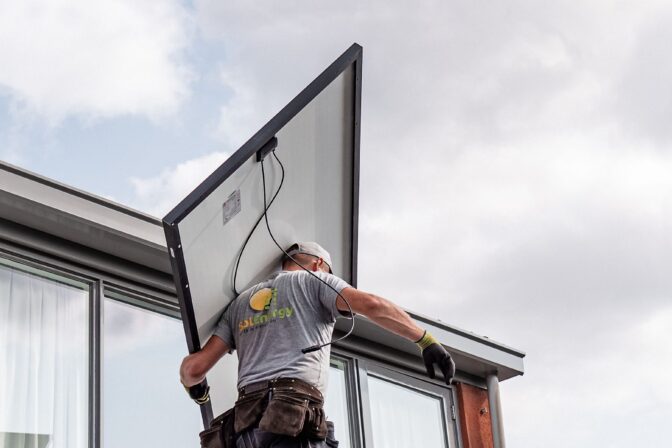 Tecnico che installa un pannello fotovoltaico sul tetto
